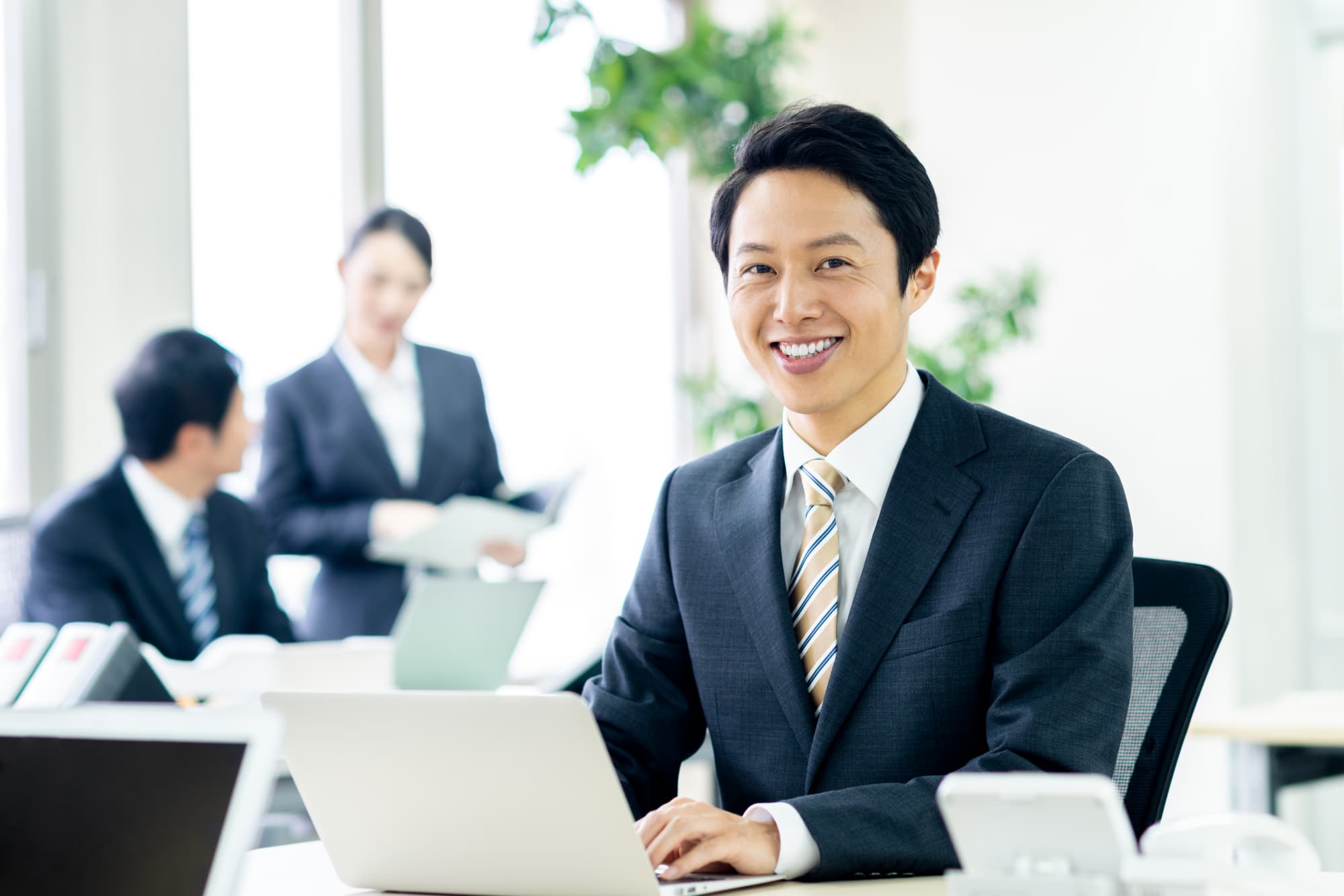 ブリッジ治療をした男性が笑顔で仕事に励んでいるイメージ